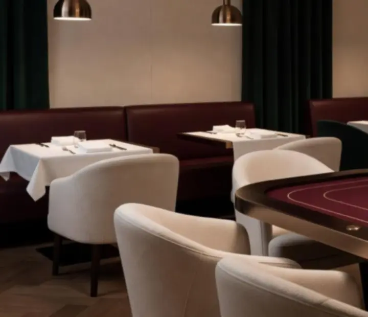 Elegancki salon pokerowy w restauracji Przystań Smaku, wieczorne światło, stół pokerowy i goście.
